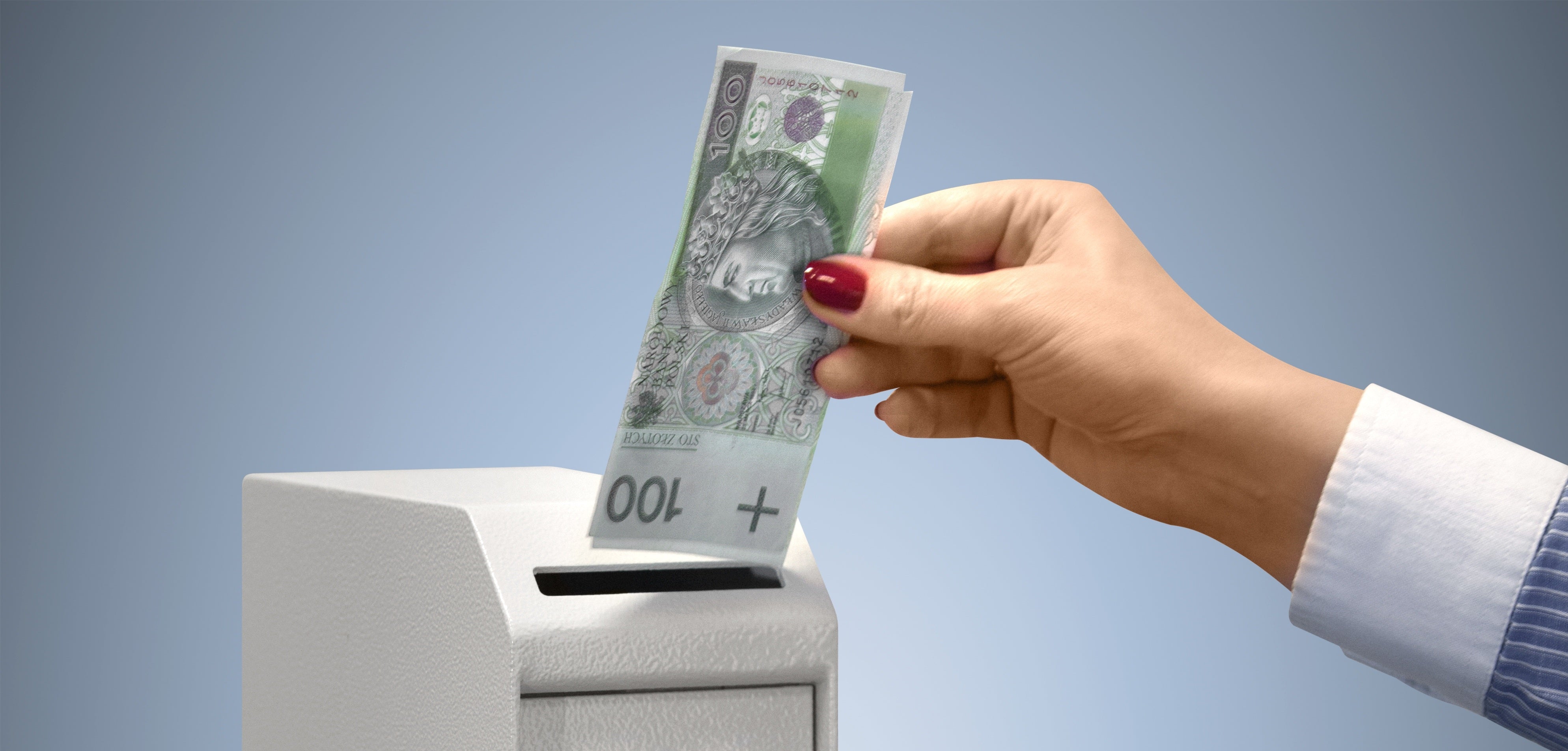 ręka wkładająca banknoty do sejfu